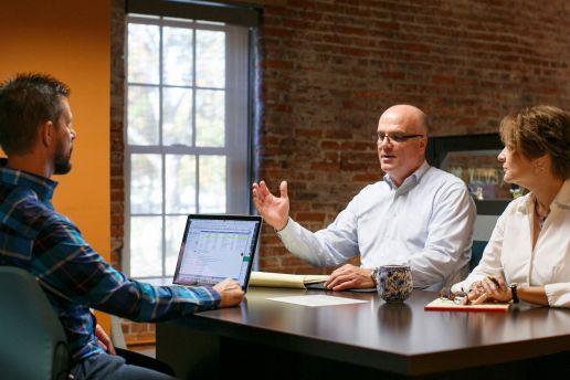 Three people meeting at a table.