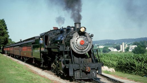 A steam engine pulling cars on a track