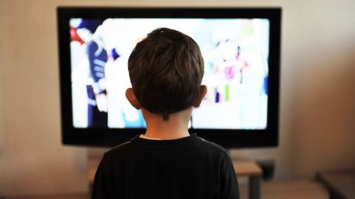 Child sitting in front of a TV screen