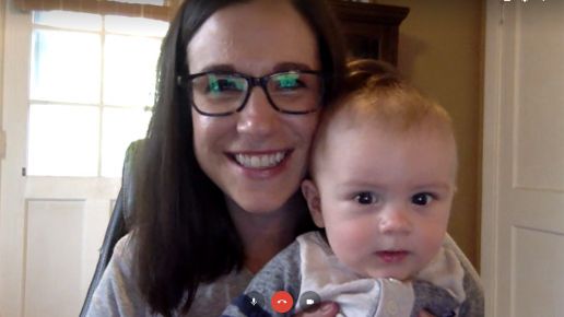 Woman holds her baby while on a video chat