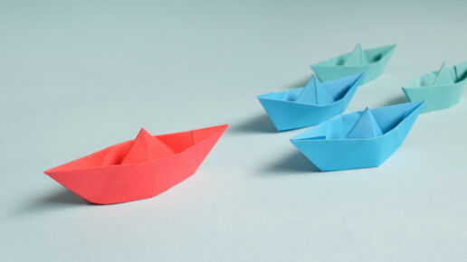 Proactive origami boat leading other boats in a race